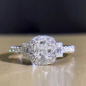Macro shot of cushion-cut zircon wedding ring with double halo and paved side stones