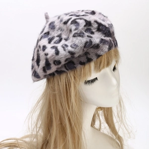 Detail of grey leopard print rabbit fur beret showing plush faux fur texture on model