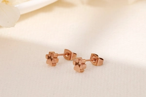 Vue macro de boucles d'oreilles pattes d'animaux en acier inoxydable or rose