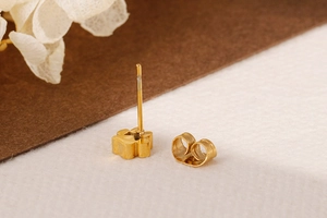 Vue macro d'une boucle d'oreille patte en acier dore 18 carats avec son fermoir