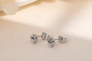 Vue rapprochée des boucles d'oreilles minimalistes en acier argenté forme patte