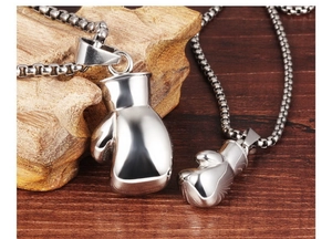 Macro shot of silver boxing glove pendants on textured wood with stainless steel box chains