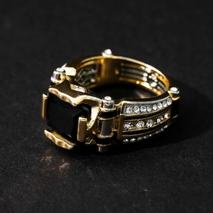 Macro detail of men's gold ring featuring black square gemstone and side crystal accents