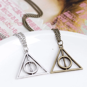 Detailed macro of Harry Potter Deathly Hallows triangle pendants in silver and bronze finish