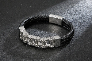 Detail of black woven leather bracelet with stainless steel gear chain gear decoration