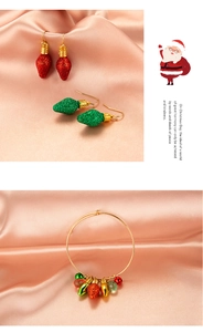 Detail of Christmas glitter bulb earrings and gold bracelet on soft silk background