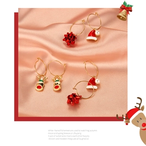Detail of Christmas earrings featuring Santa hat, reindeer, and bow designs in gold finish