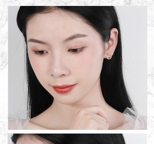 Close-up of a model wearing a gold C-shaped earring with sparkling diamond accents