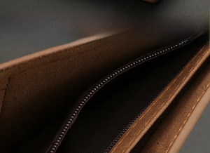 Macro view of men's leather wallet interior featuring a secure built-in zipper compartment