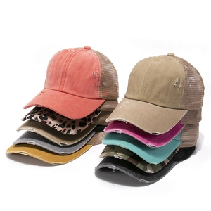 Detail of distressed ponytail baseball caps in various colors with mesh back and frayed edges