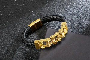 Detail of black braided leather bracelet with golden bicycle chain magnetic clasp
