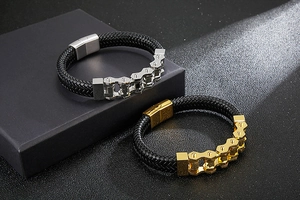 Detail of black woven leather bracelets with silver and gold bike chain metal links