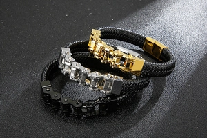 Close-up of three woven leather motorcycle chain bracelets in gold, silver, and black