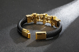 Macro shot of gold bicycle chain link on braided leather bracelet with magnetic clasp