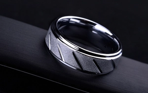 Macro shot of silver 316L stainless steel ring with matte brushed finish and diagonal grooves