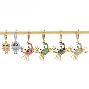 Detail view of animal earrings with zircon pavé on a bamboo stick display