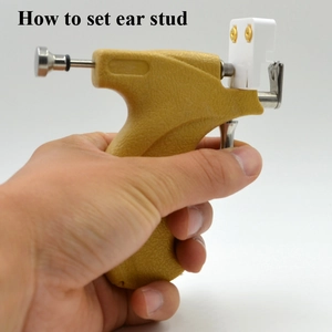Manual ear piercing gun tool with stainless steel rod and white stud base for painless use