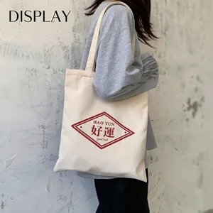 Minimalist off-white canvas tote bag with red Good Luck logo for daily student use