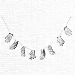 Realistic severed hand and foot props for spooky Halloween party decor on a rope