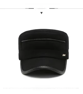 Detail view of the black cadet cap featuring leather trim and a side metal emblem