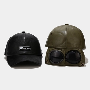 Detail of leather pilot hats featuring aviator goggles and hand made woven label