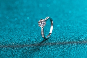 Macro shot of 1-carat moissanite ring with six-prong setting and pavé diamonds