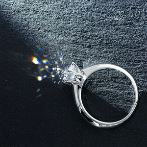 Classic silver six-prong crown ring with brilliant round cut moissanite on dark surface