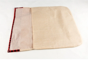 Detail of beige linen Christmas chair cover with festive red and black plaid trim accents