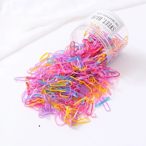 Vue macro de 500 élastiques à cheveux nacrés sortant d'une boîte de rangement pratique