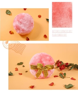 Close-up of pink plush powder puffs featuring a golden glitter butterfly bow detail