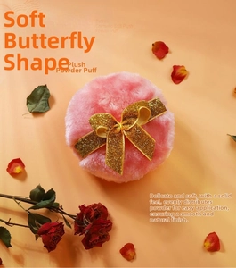 Detailed close-up of pink long plush makeup puff with decorative golden glitter bow