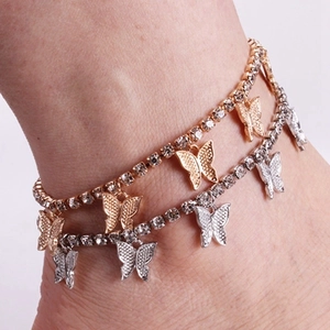 Détail de bracelets de cheville papillon à strass en or et argent sur le modèle