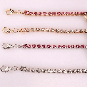 Détail de quatre bracelets de cheville en strass dorés et argentés avec des pierres roses et blanches