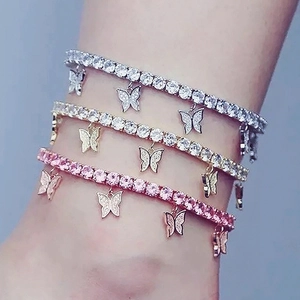 Bracelets de cheville papillon en or, argent et rose portés ensemble sur la cheville