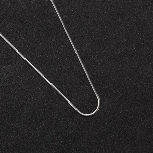 2mm silver stainless steel flat snake chain necklace on a textured black surface