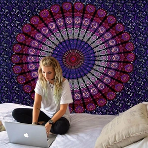 Detail of bohemian mandala tapestry hanging on a bedroom wall as a decorative backdrop