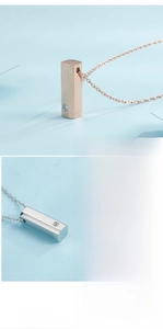 Detail of minimalist hexagonal column pendant necklace with zircon in rose gold and silver