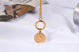 Macro detail of gold coin pendant featuring Queen Elizabeth II relief on a round chain