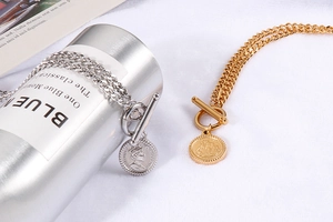 Macro view of gold and silver queen coin necklaces with OT toggle clasp on cuban chains