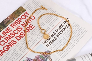 Detail of vintage gold chunky chain necklace with queen coin pendant and OT toggle clasp