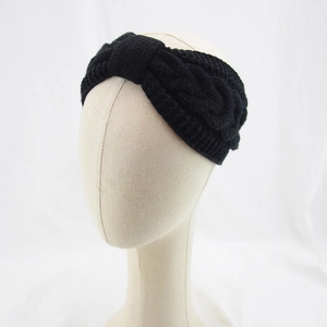 Detail of black cable-knit winter headband with elegant twisted knot texture for women