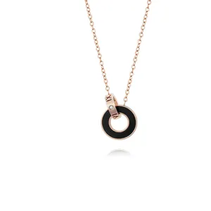 Détail du pendentif à double anneau en or rose avec chiffres romains et cristal serti