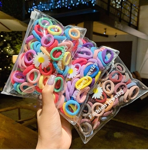 Colorful high-elastic baby hair ties in a daisy zipper bag shown against bokeh lights
