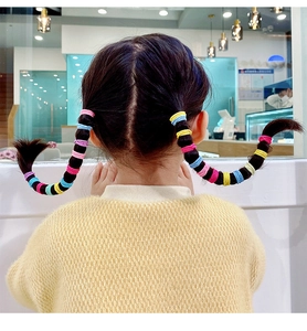Detailed view of colorful high-elastic hair ties used on children's braided pigtails
