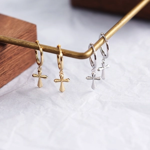 Detail view of minimalist gold and silver S925 sterling silver cross hoop earrings