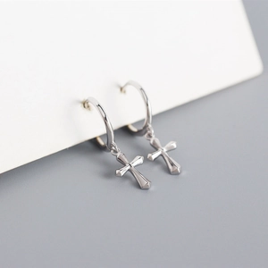 Detailed close-up of polished S925 sterling silver hoop earrings with 3D cross charms