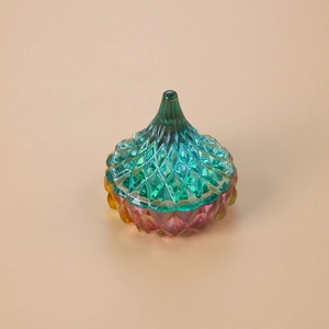 Detail of gradient faceted resin jar with green to pink finish and pointed lid
