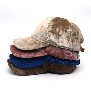 Dettaglio di cappellini da baseball in velluto nei colori kaki, viola, blu e marrone