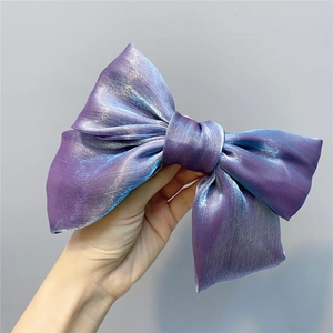 Close-up of a large purple organza bow hair clip with shimmering pearlescent finish