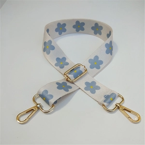 Detail of adjustable floral shoulder strap with blue flowers and golden lobster clasps